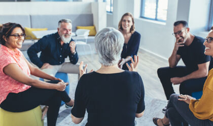 Geschäftsteam sitzt im Kreis und diskutiert