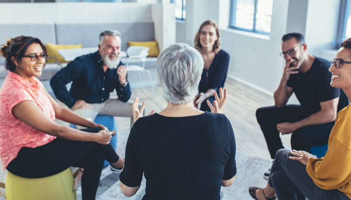 Geschäftsteam sitzt im Kreis und diskutiert