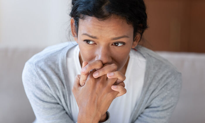 Nachdenkliche afroamerikanische junge Frau mit Depression schaut gedankenverloren in die Ferne.