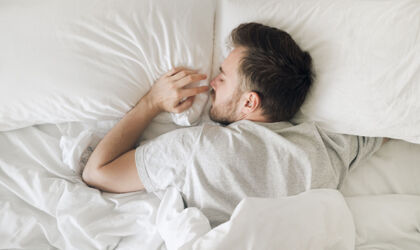 Schlafender Mann in weißem Bett