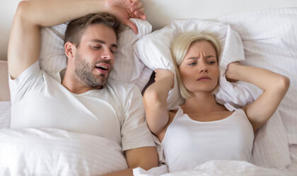 Schnarchender Mann und schlaflose Frau im Bett