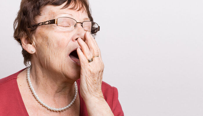 müde Seniorin gähnt