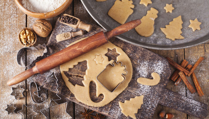 Weihnachtsbäckerei mit Nudelholz, Teig und Ausstechern auf einem Holztisch