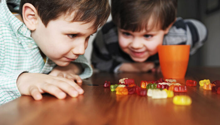 Zwei Jungen spielen mit Süßigkeiten auf Tisch