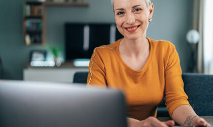 Moderne Frau, die zu Hause arbeitet. Geschäftsfrau mit Laptop und Dokumenten, Kaffee trinken. Konzentriert aussehen