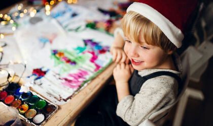 A boy draws pictures for Christmas
