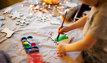 A boy is painting Christmas decorations