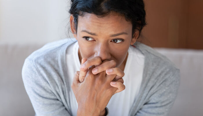 Nachdenkliche afroamerikanische junge Frau mit Depression schaut gedankenverloren in die Ferne.