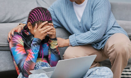 Porträt eines depressiven Mädchens, das auf dem Boden weint, während seine Mutter es tröstet