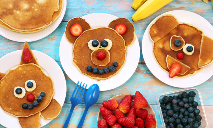Satz von Tellern mit lustigen Pfannkuchen. Kreative Idee für Kinderfrühstück