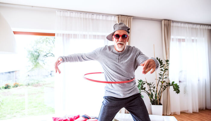 Junggebliebener älterer Mann mit Hula Hoop Reifen