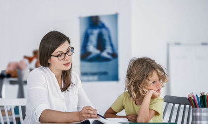 Ein gelangweilter unkonzentrierter Junge mit seiner Mutter während der Hausaufgaben