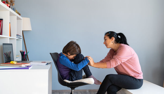 Mutter im Gespräch mit gelangweilten Jungen im Schulalter 